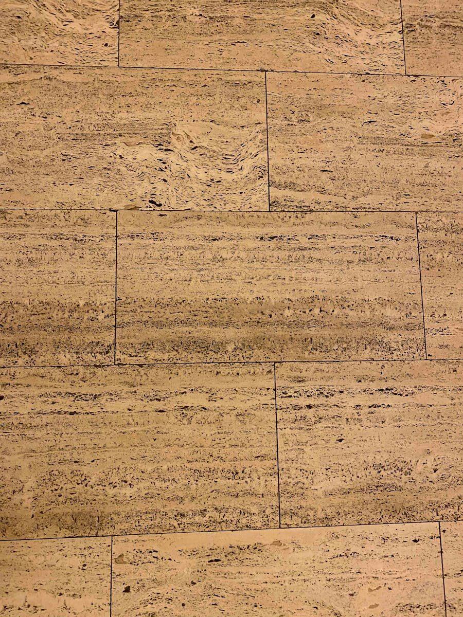 A minimalist view of a textured tile floor with natural patterns and beige color, ideal for background use.
